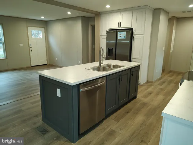 a kitchen with a wooden floor and entrance