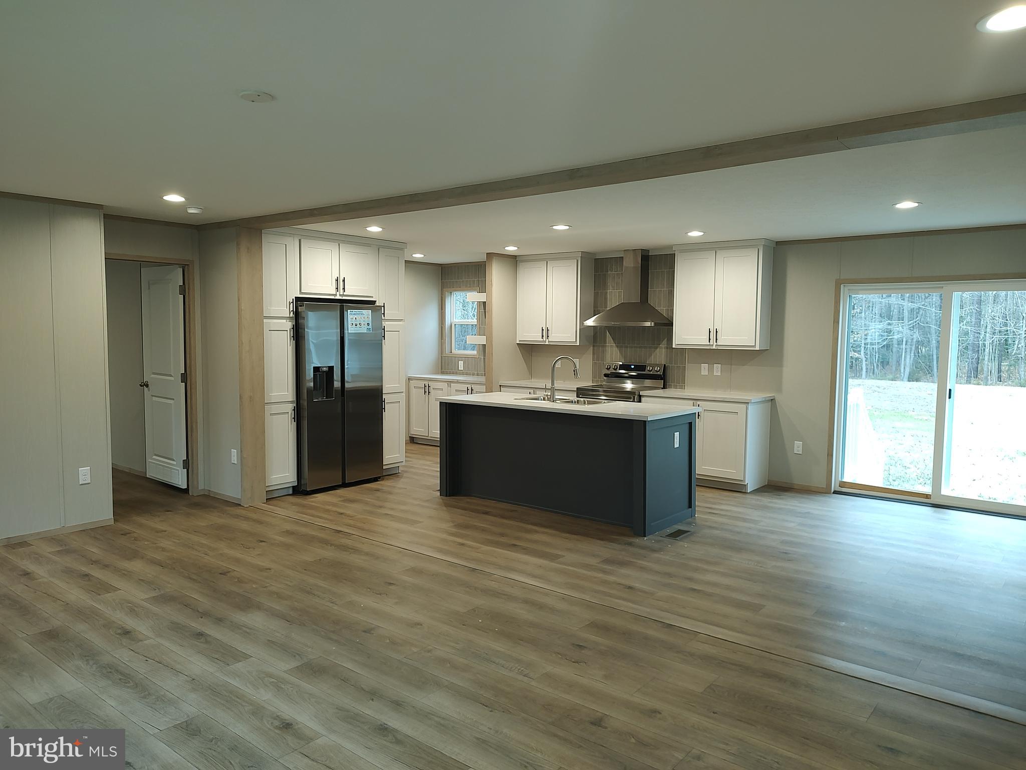 22525 Cedar Lane Georgetown, DE 19947 - Photo 7 of 24 a large kitchen with stainless steel appliances granite countertop a refrigerator and a sink