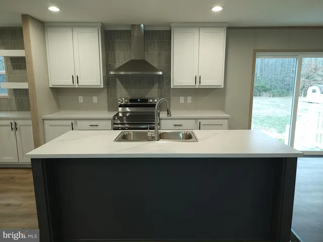 a kitchen with a sink a stove and a wooden floors