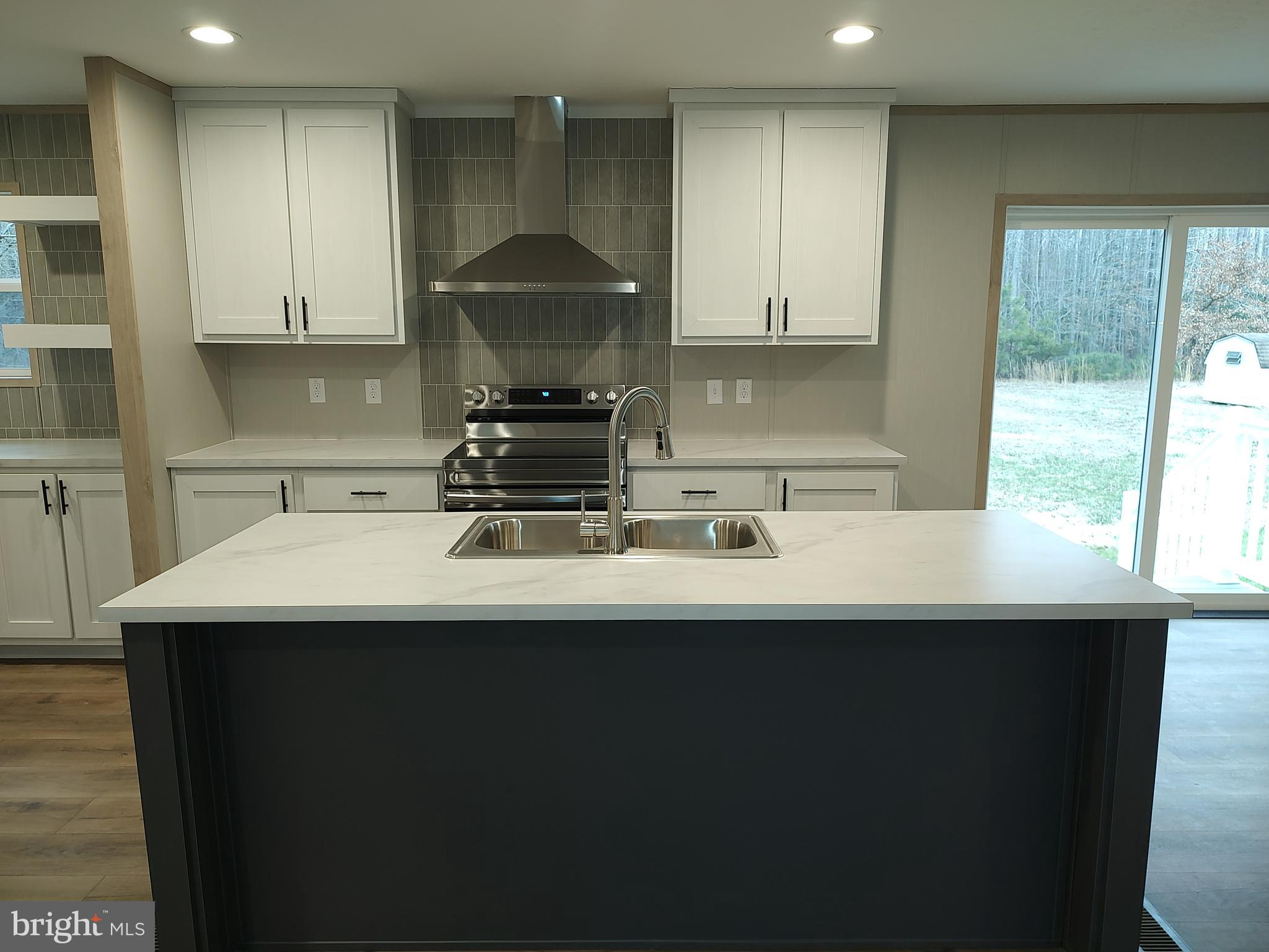 22525 Cedar Lane Georgetown, DE 19947 - Photo 8 of 24 a kitchen with a sink a stove and a wooden floors