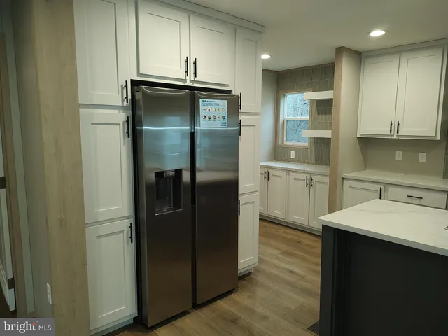 a kitchen with stainless steel appliances granite countertop a refrigerator and a sink