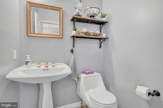 a bathroom with a sink mirror and toilet