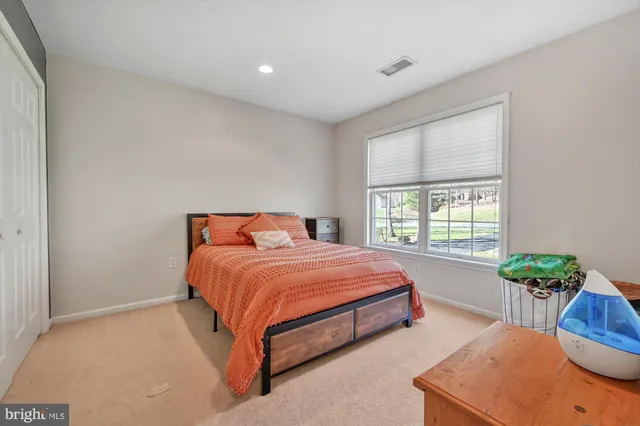 a bed sitting in a bedroom next to a window