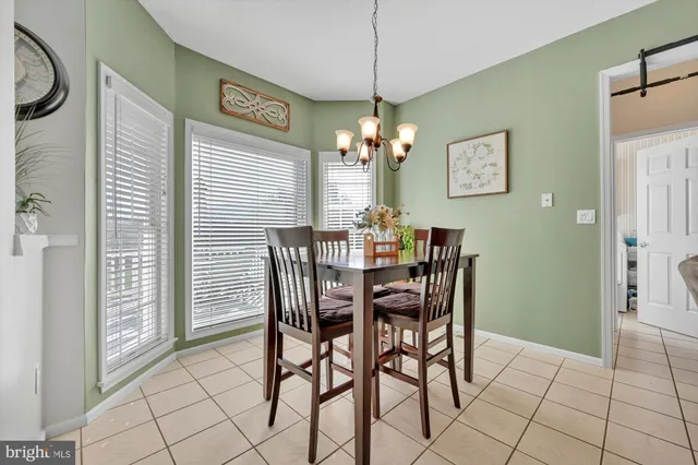a dining room with furniture a chandelier and window