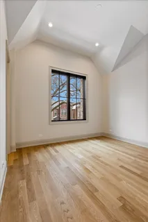 a view of an empty room with wooden floor and closet