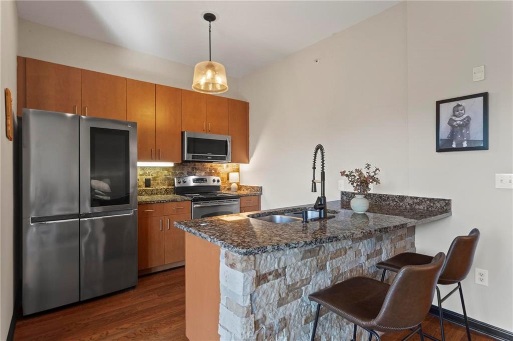 5300 Peachtree Road, Unit 4514 Atlanta, GA 30341 - Photo 11 of 38 a kitchen with stainless steel appliances granite countertop a sink refrigerator a dining table and chairs
