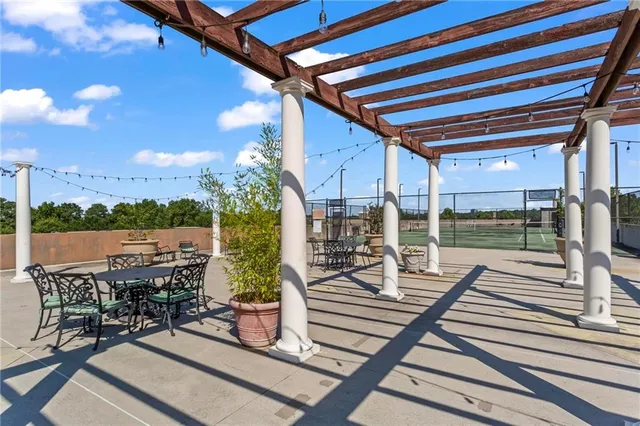a view of a patio with dining table and chairs with wooden floor and fence