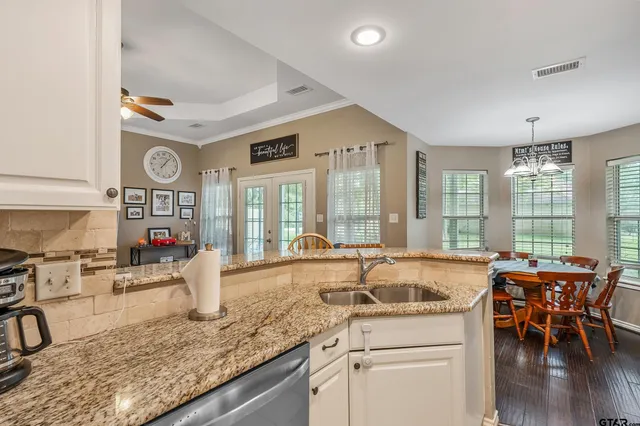 a kitchen with granite countertop sink and cabinets