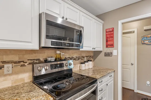 a kitchen with stainless steel appliances granite countertop a stove and a microwave