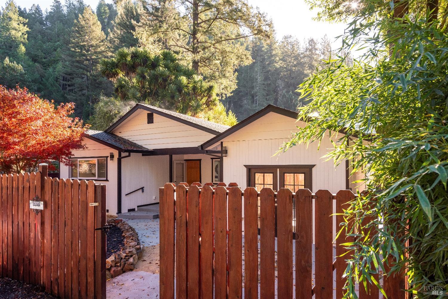 a view of a large house with a large windows and wooden fence