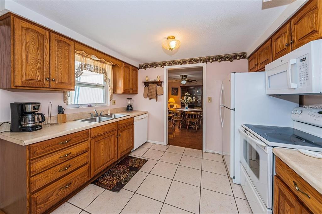 4902 Vision Avenue Holiday, FL 34690 - Photo 12 of 25 a kitchen with stainless steel appliances granite countertop a stove a sink and a refrigerator