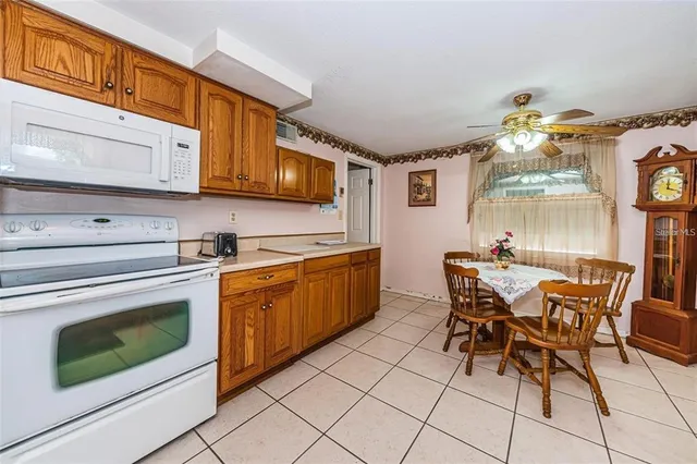 a kitchen with stainless steel appliances granite countertop a stove a sink dishwasher and a microwave oven with white cabinets