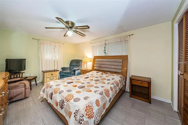 a bedroom with a bed a couch and a chandelier