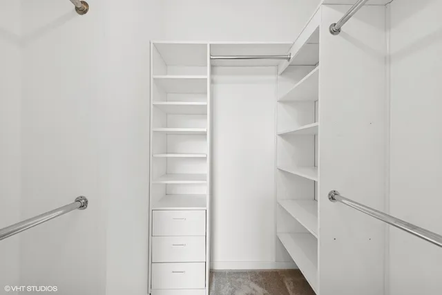 a view of walk in closet with empty racks