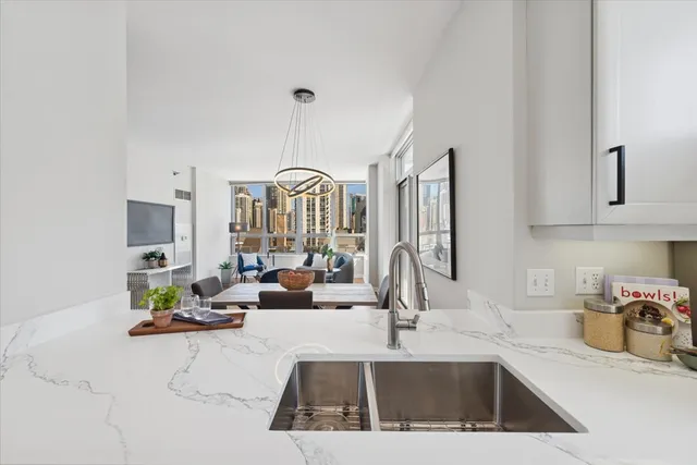 a kitchen with kitchen island granite countertop a sink chairs and cabinets