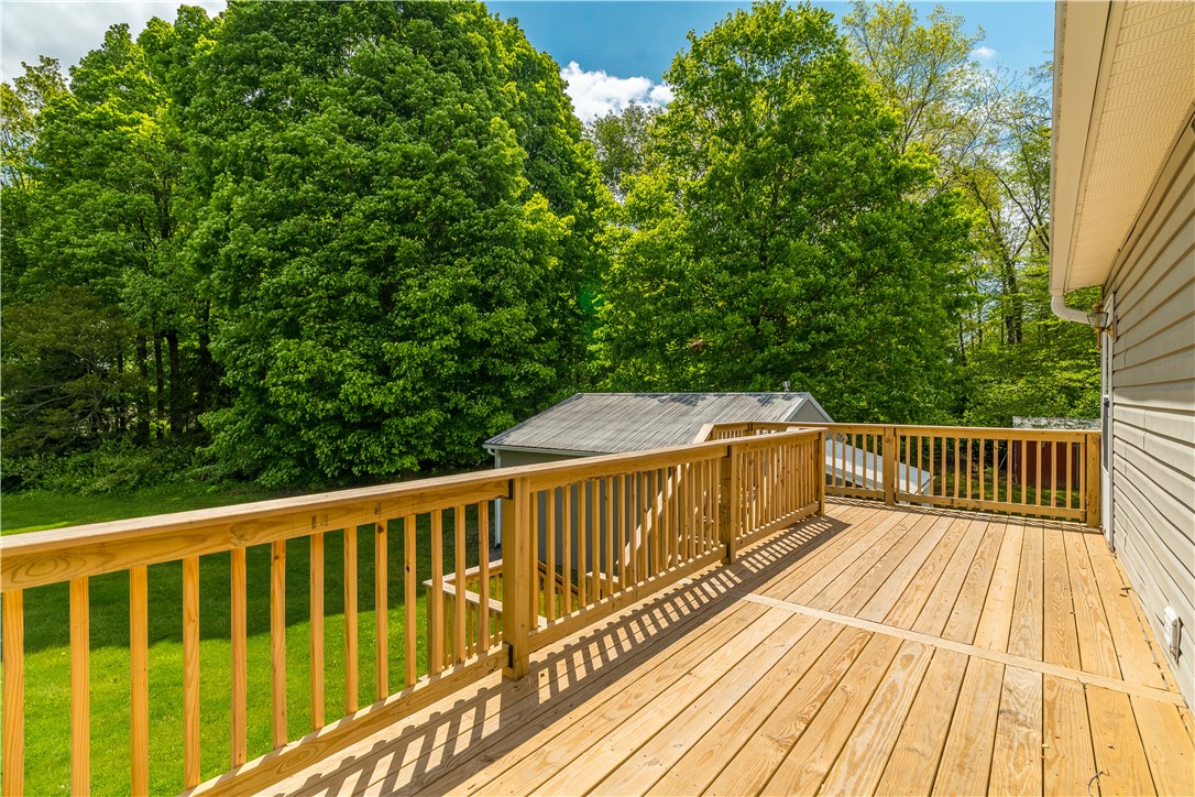 1319 Perry Road Cable, OH 43009 - Photo 36 of 44 Step outside onto this spacious wooden deck, perfect for outdoor entertaining amidst lush greenery.
