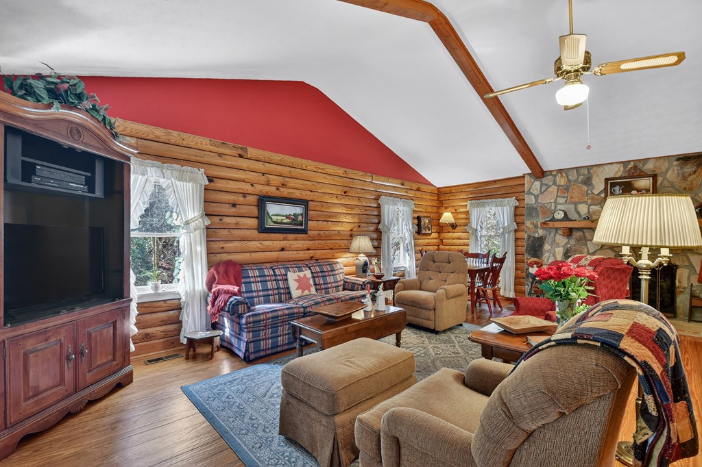 7233 Shakerag Road Ellijay, GA 30540 - Photo 24 of 117 a living room with furniture a flat screen tv and a floor to ceiling window
