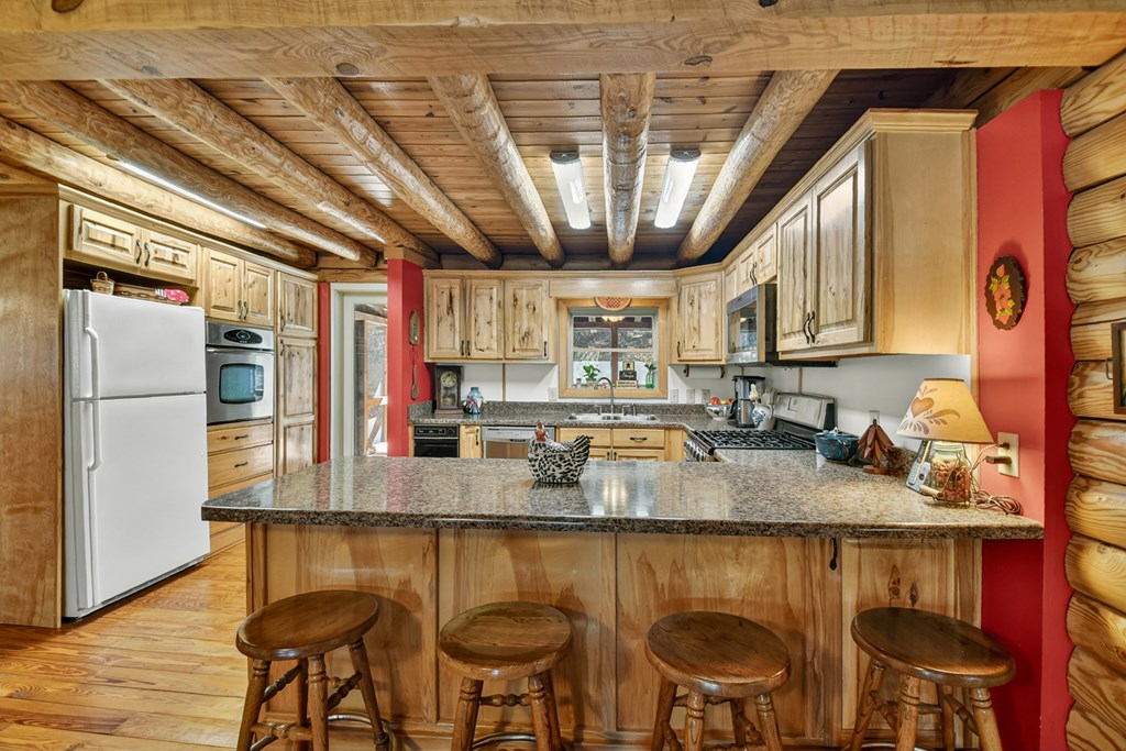 7233 Shakerag Road Ellijay, GA 30540 - Photo 68 of 117 a kitchen with stainless steel appliances granite countertop a table chairs in it and wooden floors