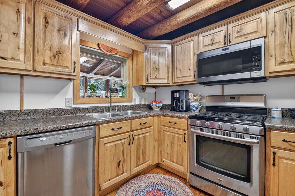 7233 Shakerag Road Ellijay, GA 30540 - Photo 9 of 117 a kitchen with stainless steel appliances granite countertop a stove microwave and sink