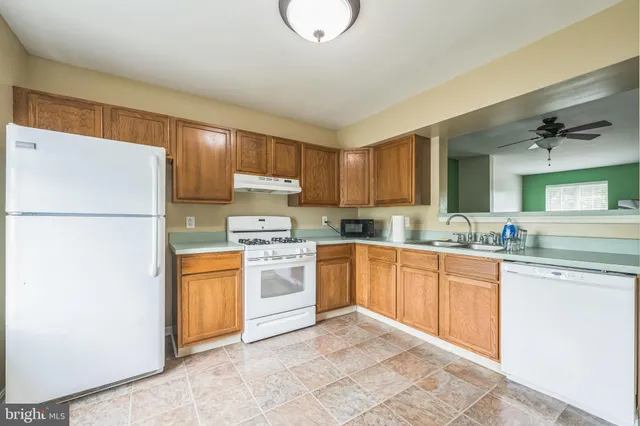 a kitchen with stainless steel appliances granite countertop a refrigerator sink stove and oven