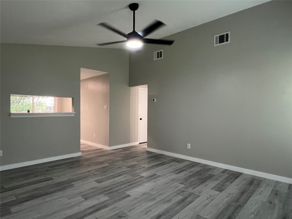 10510 Little Pebble Drive, Unit B Austin, TX 78758 - Photo 2 of 15 an empty room with wooden floor chandelier fan and closet area