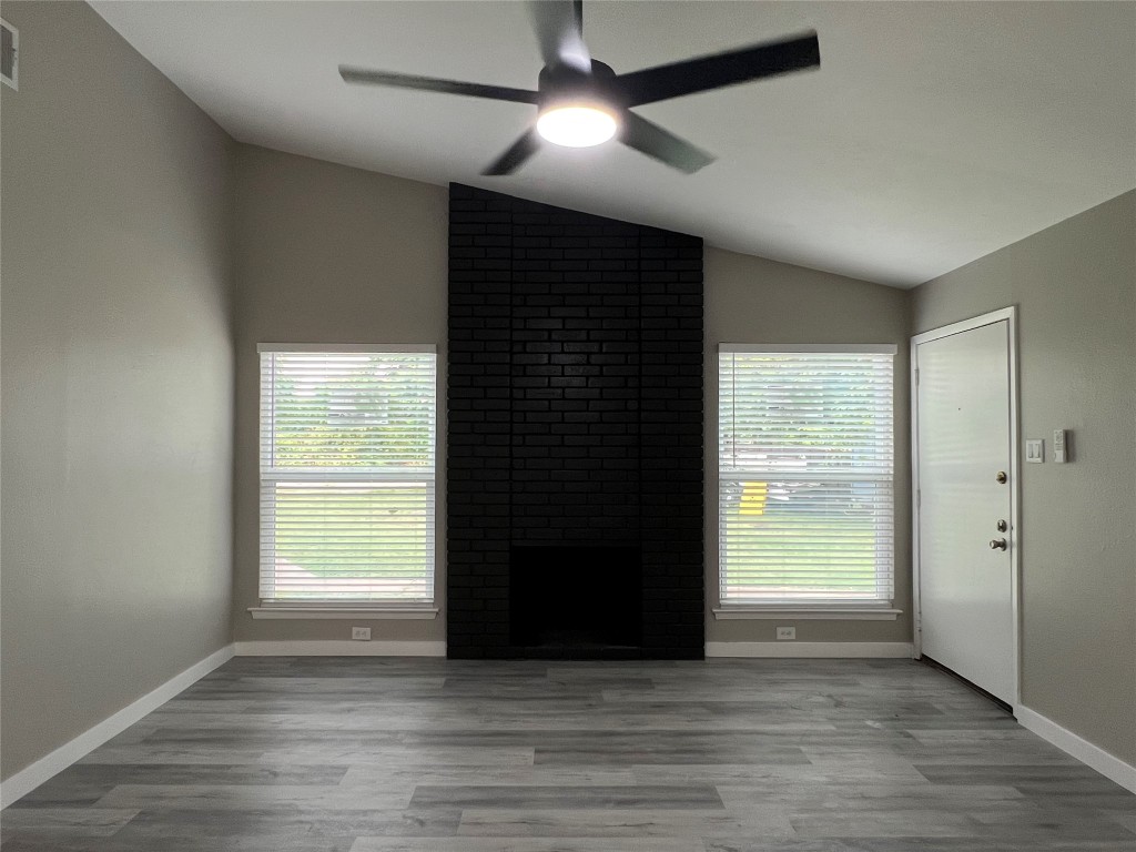 10510 Little Pebble Drive, Unit B Austin, TX 78758 - Photo 3 of 15 an empty room with wooden floor and windows