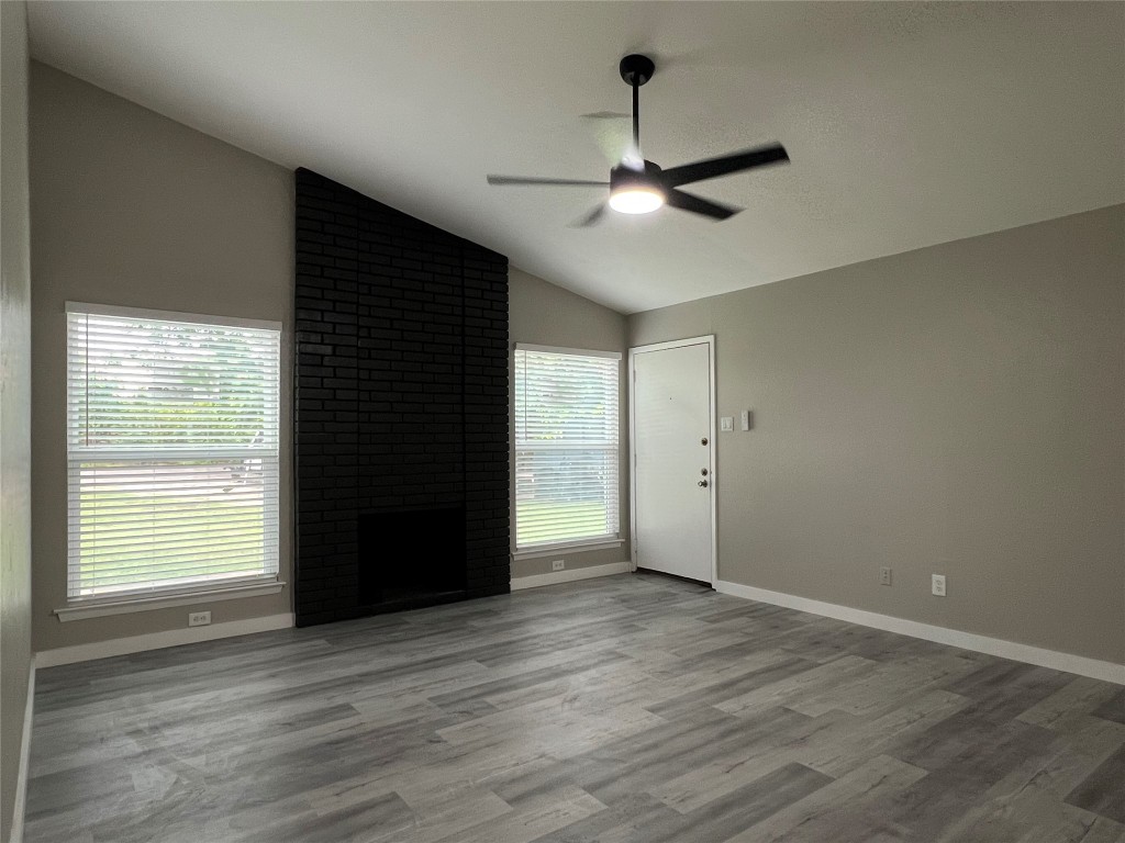10510 Little Pebble Drive, Unit B Austin, TX 78758 - Photo 4 of 15 an empty room with wooden floor cabinet and windows