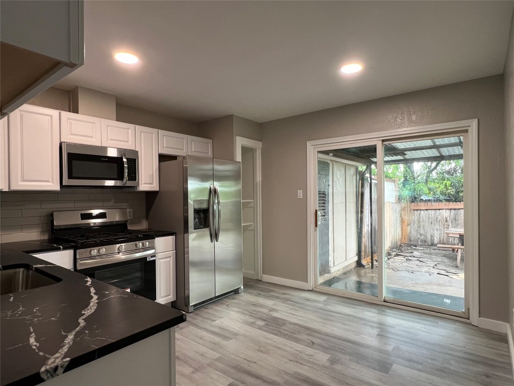 10510 Little Pebble Drive, Unit B Austin, TX 78758 - Photo 5 of 15 a kitchen with stainless steel appliances granite countertop a refrigerator a stove top oven a sink and dishwasher