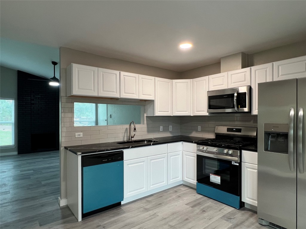 10510 Little Pebble Drive, Unit B Austin, TX 78758 - Photo 6 of 15 a kitchen with granite countertop a refrigerator and a stove top oven