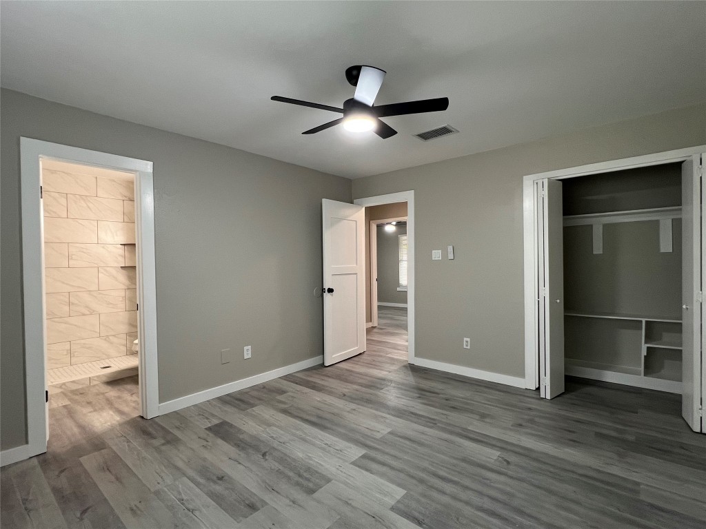 10510 Little Pebble Drive, Unit B Austin, TX 78758 - Photo 7 of 15 an empty room with wooden floor a ceiling fan and windows