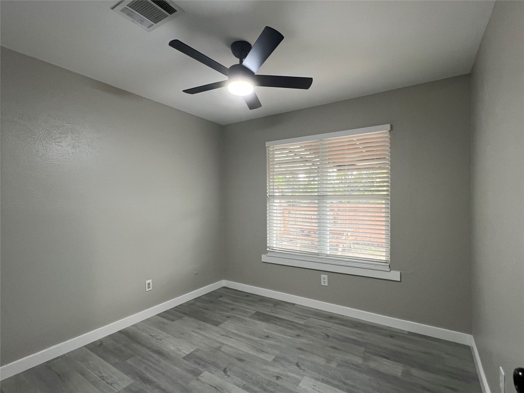 10510 Little Pebble Drive, Unit B Austin, TX 78758 - Photo 9 of 15 an empty room with wooden floor and windows