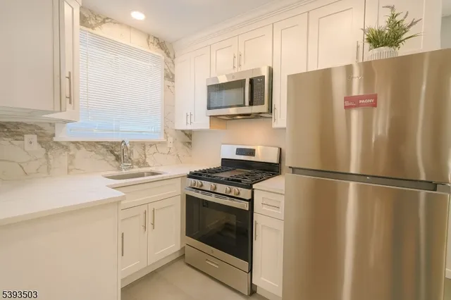 a kitchen with stainless steel appliances a refrigerator sink and microwave
