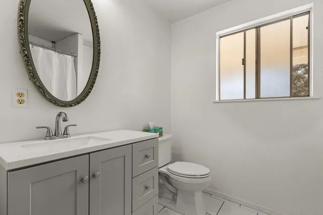 a bathroom with a toilet a sink and a mirror