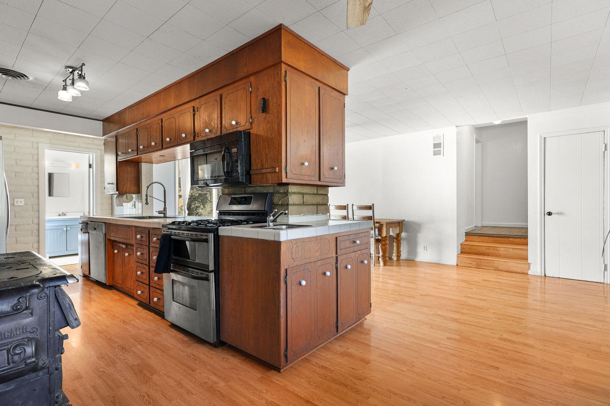 14207 Main Street French Gulch, CA 96033 - Photo 8 of 38 a kitchen with stainless steel appliances granite countertop a stove a sink dishwasher a refrigerator and a dining table with wooden floor