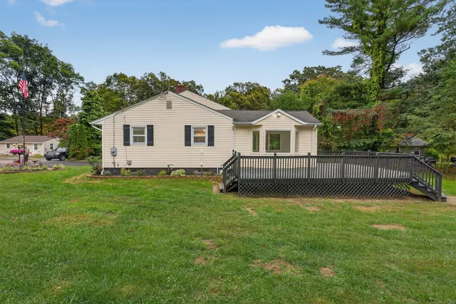 a view of a house with a yard potted plants and a tree