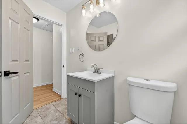 a bathroom with a sink a toilet and a mirror