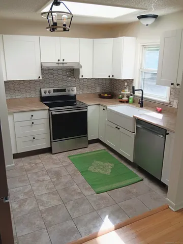 a kitchen with a stove cabinets and window