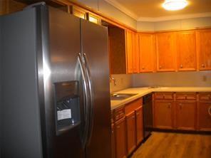 617 Laura Street Mansfield, LA 71052 - Photo 3 of 9 a kitchen with a refrigerator and a sink