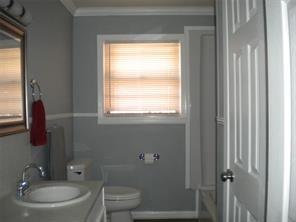 617 Laura Street Mansfield, LA 71052 - Photo 4 of 9 a bathroom with a toilet a sink and a mirror
