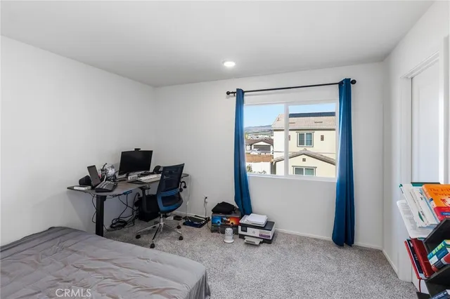 a view of a workspace with furniture and a window