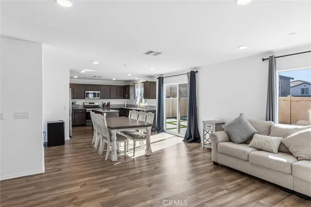 a living room with furniture and view of kitchen
