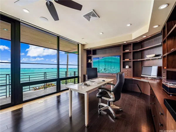 a view of a workspace with furniture and floor to ceiling window