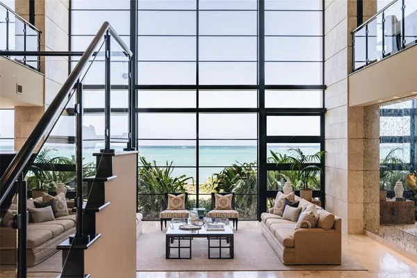 a living room with furniture and floor to ceiling windows