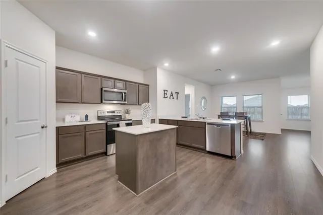 a kitchen with a sink wooden floor and kitchen view