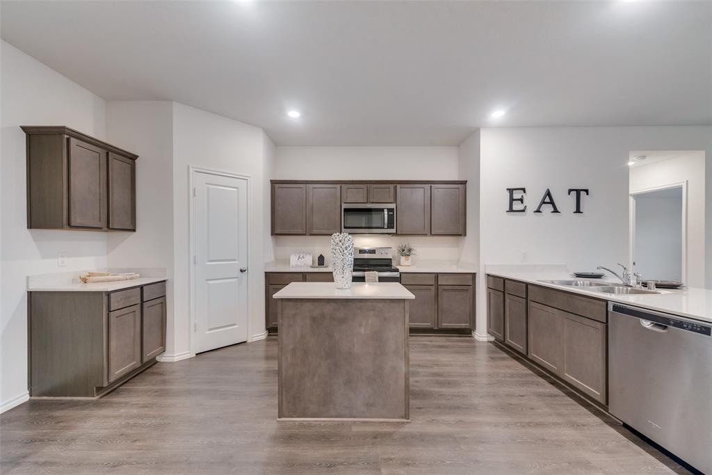1413 Thunder Cyn Way Royse City, TX 75189 - Photo 8 of 24 a large kitchen with cabinets wooden floor and stainless steel appliances