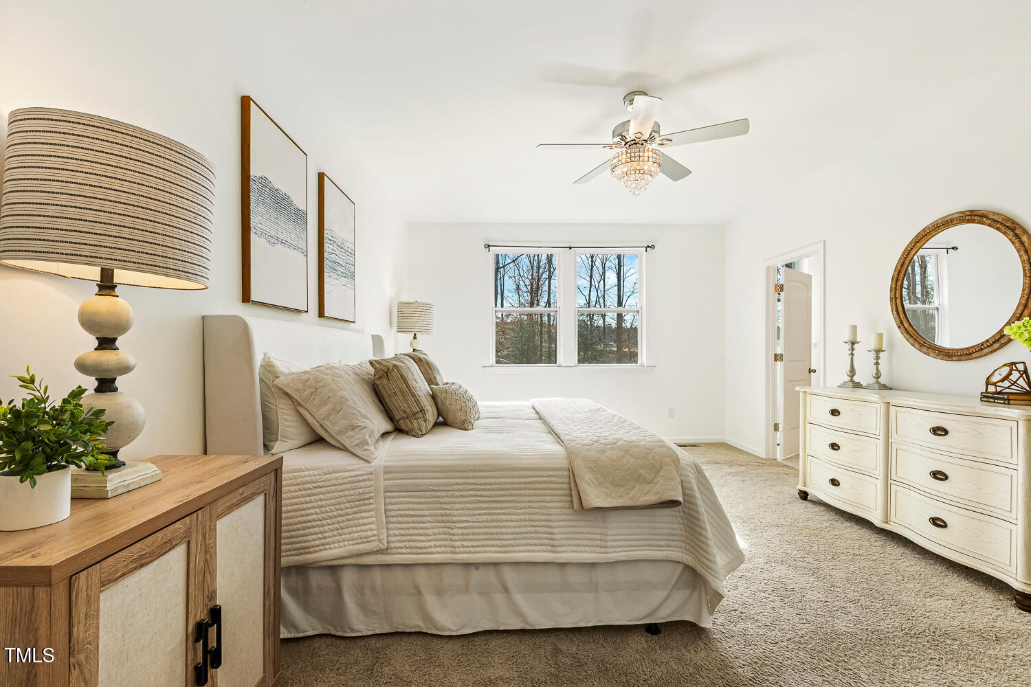 143 Rossell Park Circle Garner, NC 27529 - Photo 19 of 42 a bedroom with a bed a chandelier and a dresser