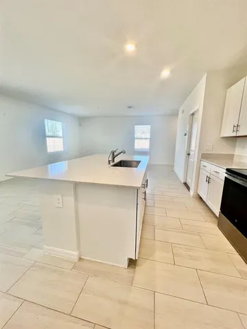 a kitchen with stainless steel appliances a sink stove and cabinets
