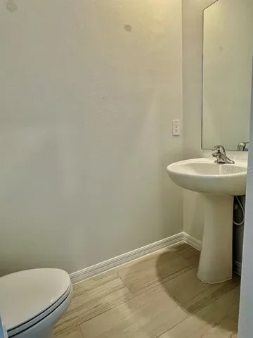 a bathroom with a sink a toilet and mirror
