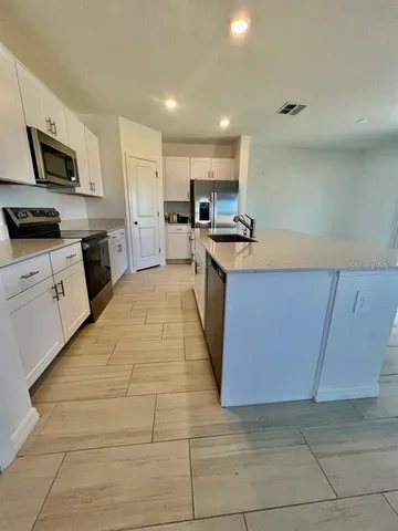 a large kitchen with stainless steel appliances granite countertop a large counter top and a stove top oven