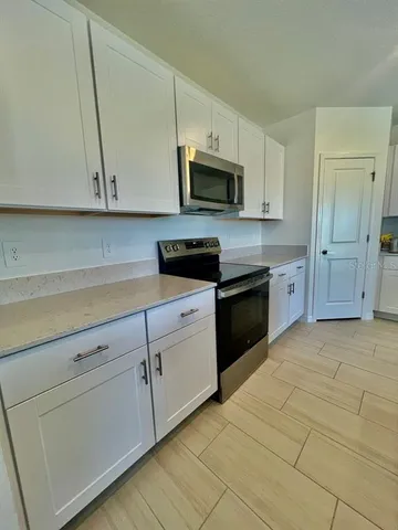 a kitchen with white cabinets stainless steel appliances and sink